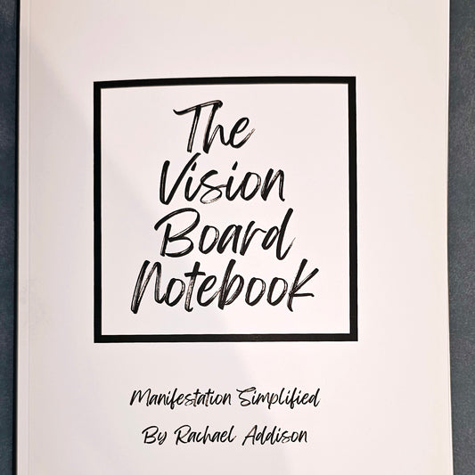 White notebook with black text The Vision Board Notebook: Manifestation Simplified. Wordkind.