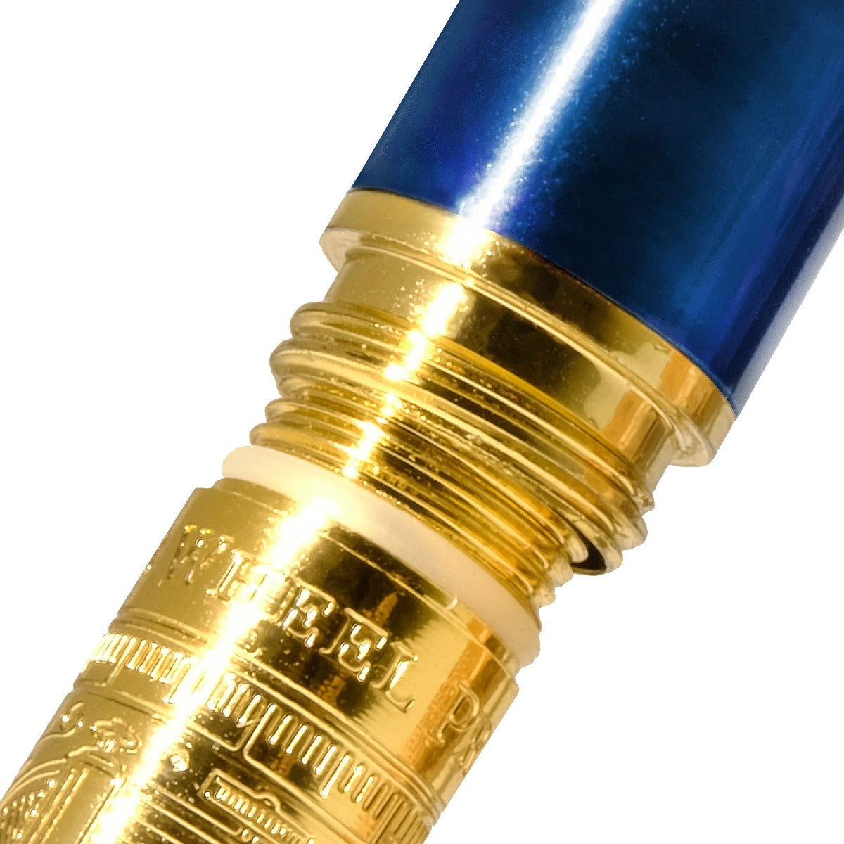 "Close-up of sapphire blue lacquer and gold-plated nib with intricate engravings on a fountain pen. Wordkind.