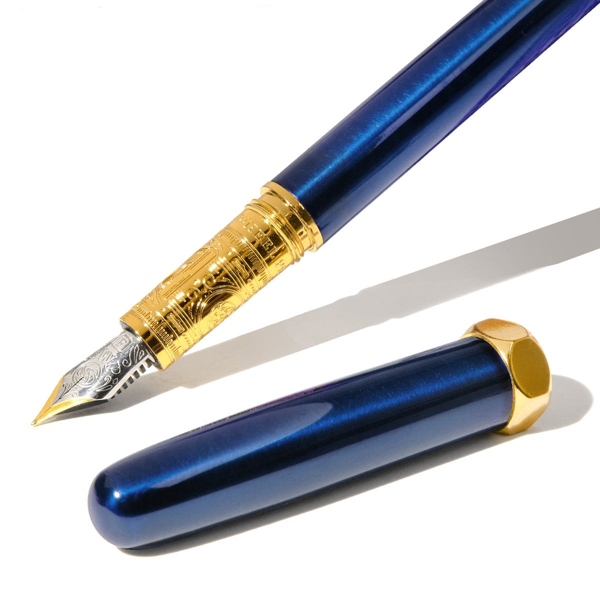 Close up of sapphire blue fountain pen with intricately engraved nib. Wordkind.