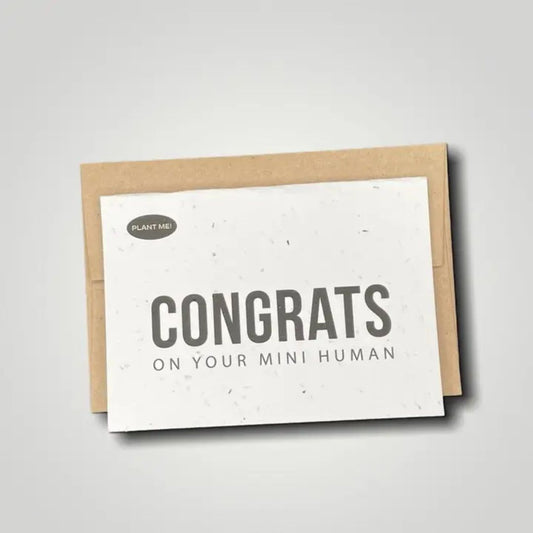New baby seed paper greeting card with congratulations on your mini human in bold black text. Wordkind.