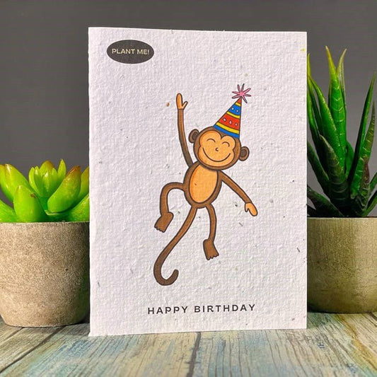 Seed paper birthday card with a dancing monkey in a party hat and Happy Birthday text. Wordkind.